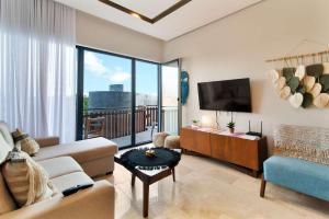 a living room with a couch and a tv at One block from beach in Hotel Zone Free Beach Club in Tulum +34 photos