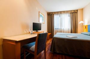 um quarto de hotel com uma secretária e uma cama em Hotel Villacarlos em Valência
