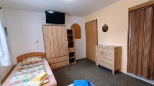 a bedroom with a bed and a dresser with a tv at Pension 444 - Ski Resort Herlikovice and Bubakov in Vrchlabí