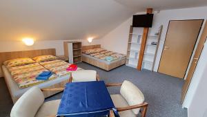 a room with two beds and a table and chairs at Pension 444 - Ski Resort Herlikovice and Bubakov in Vrchlabí