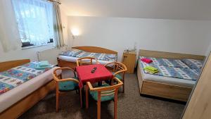 a small room with two beds and a table and chairs at Pension 444 - Ski Resort Herlikovice and Bubakov in Vrchlabí