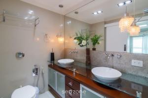 a bathroom with two sinks and a large mirror at Apto c vista mar privilegiada 4qts c suíte ETL2702 in Balneário Camboriú +34 photos