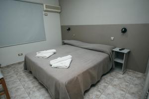 a bedroom with a bed with two towels on it at PM departamentos in San Rafael
