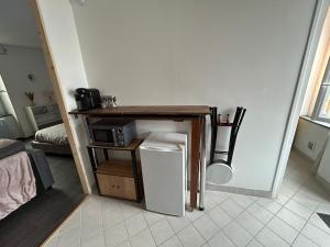 a kitchen with a small table and a refrigerator at Studio indépendant in Saint-Éloi