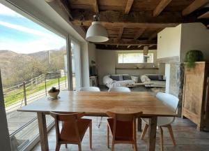 Un comedor con una gran mesa y sillas de madera. en Uthurraltia, en Larrau
