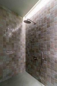 La salle de bains est pourvue d'une douche avec du carrelage brun. dans l'établissement Valencia Malvarrosa Beach point green, à Valence