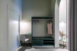 Cette chambre comprend un placard avec un bureau et une chaise. dans l'établissement Valencia Malvarrosa Beach point green, à Valence
