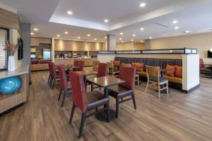 a restaurant with tables and chairs and a bar at TownePlace Suites by Marriott St. Louis Edwardsville, IL in Edwardsville