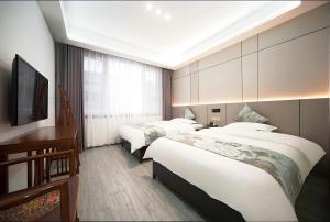 Voodi või voodid majutusasutuse Zhangjiajie Borui Hotel - Tianmen Mountain 张家界天门山泊睿庭院酒店 toas