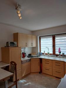 una cucina con armadi in legno, lavandino e finestra di Haus Petra a Frankenstein