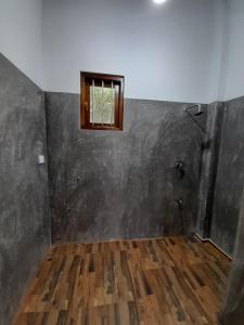 an empty room with a window and a wooden floor at Villa Tanzanite in Tangalle