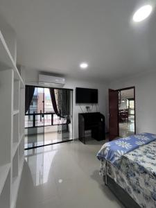 a bedroom with a bed and a desk and a television at Casa Duplex Itatiaia Penedo in Itatiaia