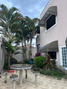 a courtyard with benches and palm trees in front of a building at Casa Duplex Itatiaia Penedo in Itatiaia