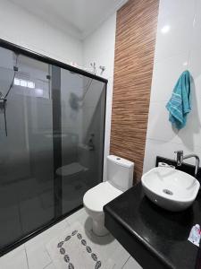 a bathroom with a shower and a toilet and a sink at Casa Duplex Itatiaia Penedo in Itatiaia +17 photos