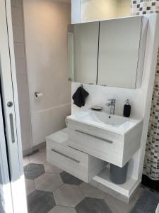 une salle de bain blanche avec un lavabo et un miroir dans l'établissement entre mer et montagne, à Peyroules