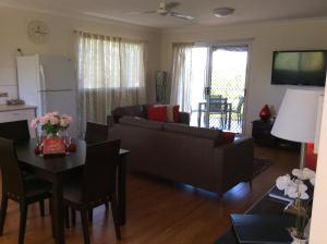 a living room with a couch and a table at Tinaroo Sunset Retreat in Barrine