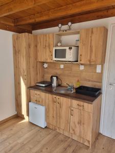 a kitchen with a sink and a microwave at Kis szilvás Kuckók in Bogács +12 photos