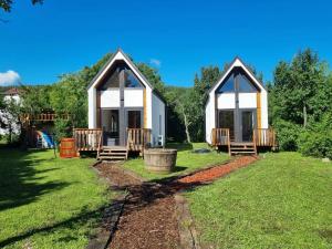two small cottages in a yard with grass at Kis szilvás Kuckók in Bogács