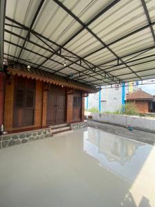 a building with awning next to a swimming pool at Guest House Brahu Syariah in Trowulan