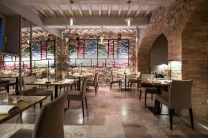 a restaurant with tables and chairs and stained glass windows at Locanda dei Logi in San Gimignano