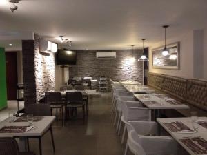 a restaurant with white tables and chairs and a brick wall at Dunia Suites Cartagena in Cartagena de Indias