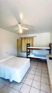 2 Betten in einem Zimmer mit Deckenventilator in der Unterkunft Hotel Villa Charmosa in São Pedro
