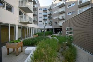 an apartment courtyard with plants and a building at Résidence NOVAGE - Amiens in Amiens