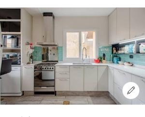 a kitchen with white cabinets and a sink at Carabelli Propiedades in Río Grande