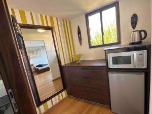 a small kitchen with a microwave and a mirror at Lovely studio on the Carmel Mt in Haifa