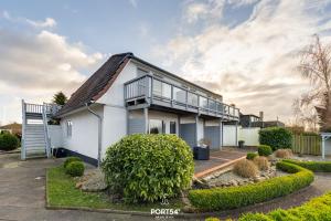 a white house with a balcony on top of it at Apartment 22 in Kappeln +10 photos