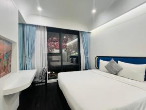 una camera da letto con un grande letto bianco e una finestra di Love & Peace Apartment a Phu Quoc