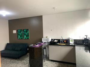 a kitchen with a counter and a couch in a room at LK Lourdes 7 in Belo Horizonte