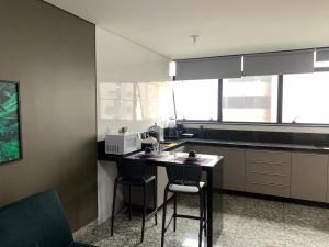 een keuken met een tafel met 2 stoelen en een magnetron bij LK Lourdes 7 in Belo Horizonte +6 foto's