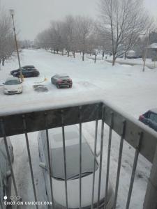 un aparcamiento cubierto de nieve con coches aparcados en él en Tranloge, en Quebec