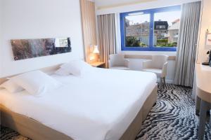a hotel room with a bed and a window at Thalazur Ouistreham - Hôtel & Spa in Ouistreham +37 photos