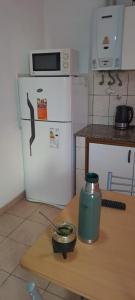 a kitchen with a refrigerator and a table with a can on it at La historica in Concepción del Uruguay +4 photos