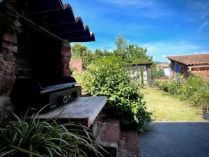 un banc en pierre assis à l'extérieur d'une maison dans l'établissement Les Terres Rouges du Salagou, à Le Bosc