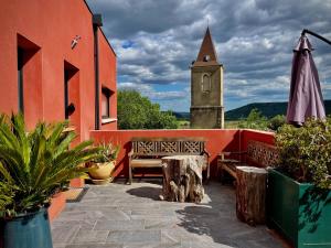 une terrasse avec un banc et une tour d'horloge dans l'établissement Les Terres Rouges du Salagou, à Le Bosc 19 autres photos