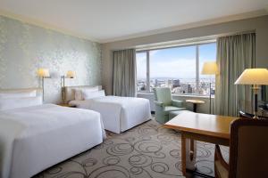 a hotel room with two beds and a desk at The Westin Osaka in Osaka