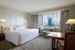 a hotel room with a bed and a desk and a window at The Westin Osaka in Osaka