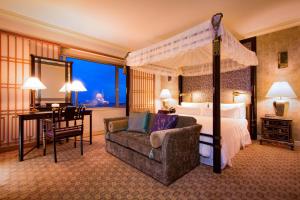 a bedroom with a canopy bed and a desk and a chair at The Westin Osaka in Osaka