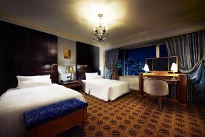 a hotel room with two beds and a desk and a window at The Westin Osaka in Osaka