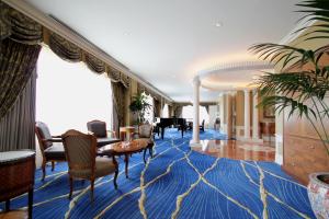 a living room with a blue carpet and a piano at The Westin Osaka in Osaka