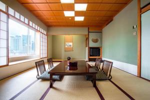 a dining room with a table and chairs and windows at The Westin Osaka in Osaka