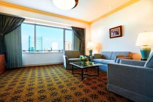 a living room with a couch and chairs and a large window at The Westin Osaka in Osaka