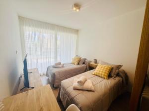 a living room with two beds and a table at Premium Studio, Confort in La Plata +16 photos