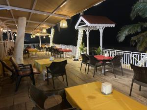 a restaurant with tables and chairs on a deck at Anthy’s Guesthouse and Restaurant in Benaulim
