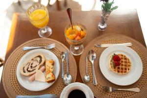 a table with two plates of breakfast food and drinks at Araucária Lodge - 800 metros do Capivari in Campos do Jordão +118 photos