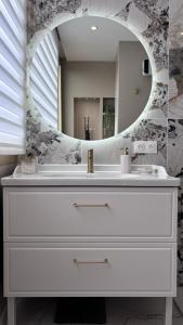 a bathroom with a white sink and a mirror at JARDIN TERRASSE EDEN SAINT TROPEZ - Parking Pool AC 4P in Saint-Tropez