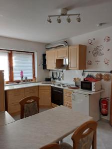 una cucina con mobili in legno e un tavolo con sedie di Haus Petra a Frankenstein